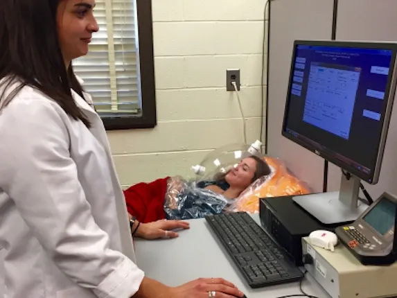 Researcher testing a participant's resting metabolic rate (RMR) using the metabolic cart. RMR refers to the energy that is required to keep your body functioning at rest.
