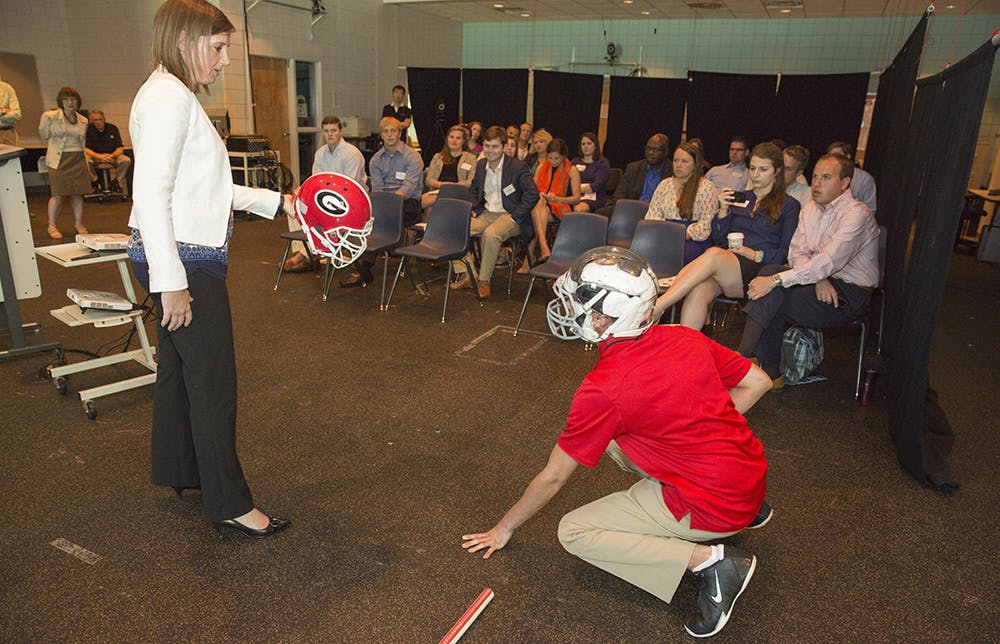 Travis Fetchko (right) and Julianne Schmidt demonstrate a helmet embedded with sensors. Photo by Peter Frey