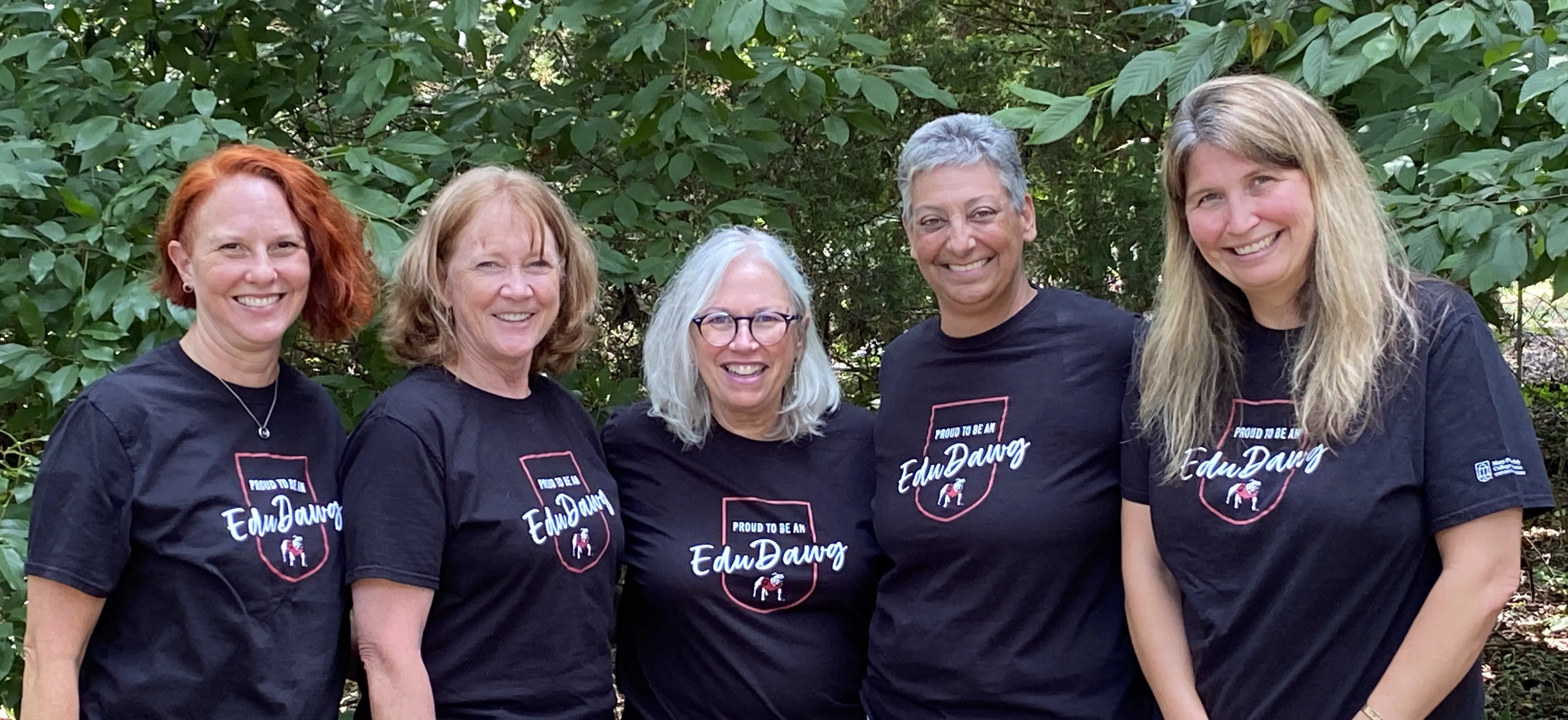 photo of GSAP Team members, standing outside with arms around each other, all wearing t-shirts that say &ldquo;Proud to be an EduDawg&rdquo;