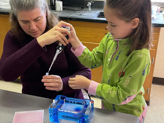 An elementary student learning to load a gel