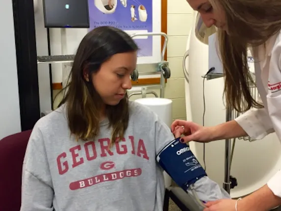 Blood pressure measurement following proper techniques. The participant's blood pressure is stabilized after resting for 5 minutes, sitting up straight with both feet flat on the ground with the cuff being placed ~2.5 cm above the bend.