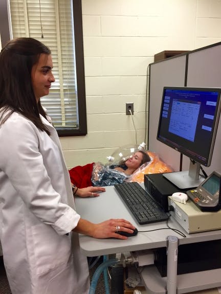 Researcher testing a participant's resting metabolic rate (RMR) using the metabolic cart. RMR refers to the energy that is required to keep your body functioning at rest.
